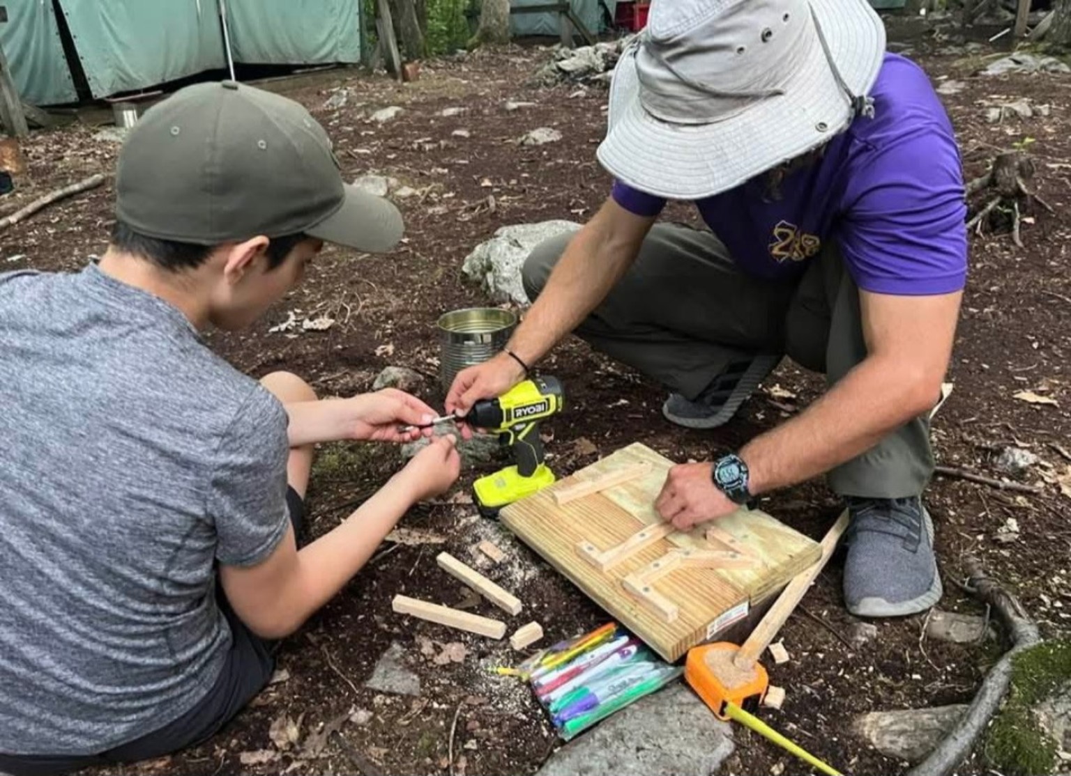 A Troop 288 Scout learning woodworking skills with adult guidance